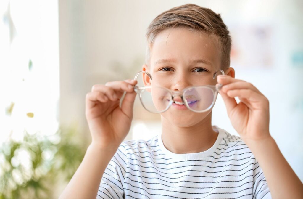 a child holding glasses up to their face